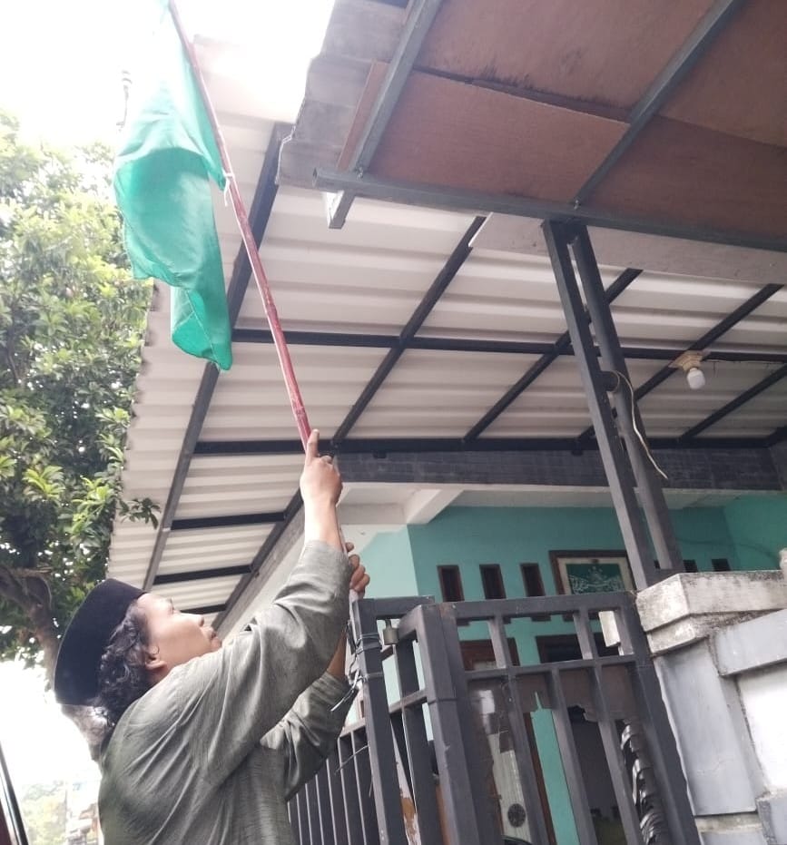 Pengibaran bendera Nahdlatul Ulama oleh anggota Anak Ranting NU Desa Cibinong